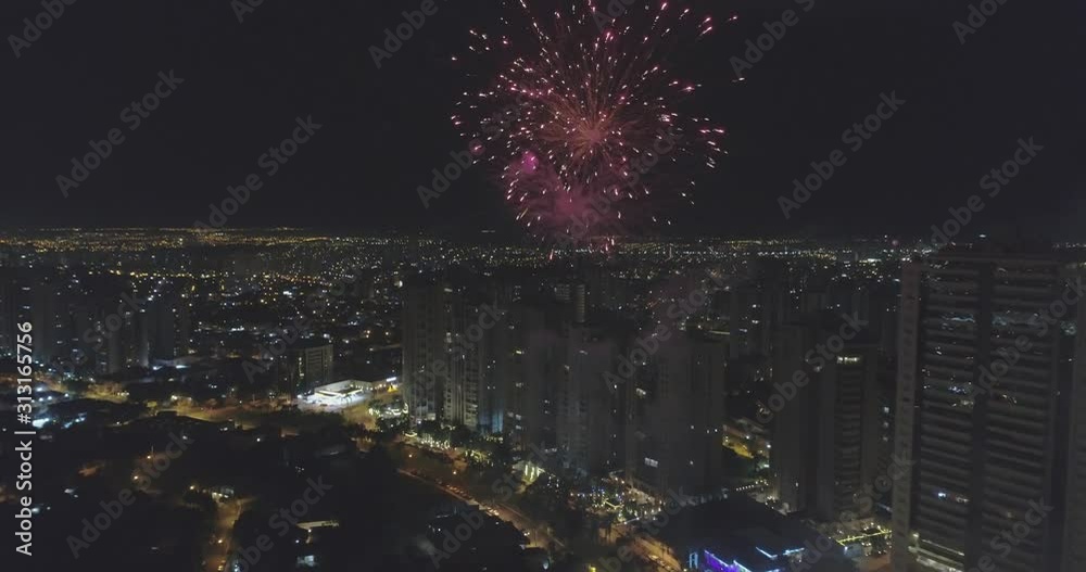 Whole city celebrating the New Year or any national event with fantastic multi-colored fireworks, night sky. Aerial view. Avenue João Fiúsa, Ribeirão Preto / Brazil. 4K.