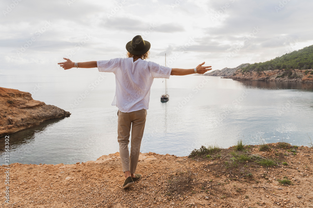 Back view of happy young man in front of the sea Back view of happy young man in front of the sea