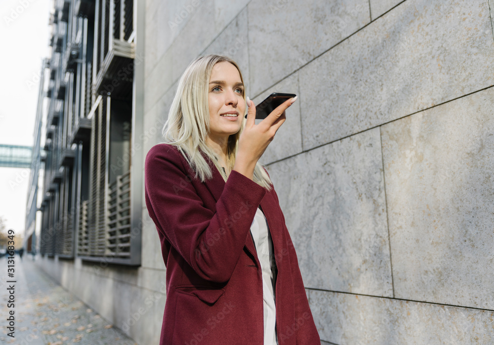 Blond businesswoman using smartphone in the city Blond businesswoman using smartphone in the city