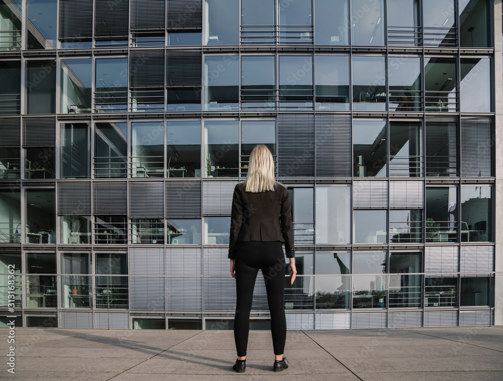 Rear view of a businesswoman in front of modern office Rear view of a businesswoman in front of modern office