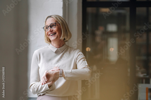 Happy mature businesswoman at the window in office photo