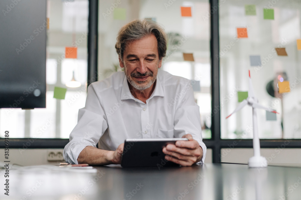 Senior businessman using tablet in conference room in office Senior businessman using tablet in conference room in office