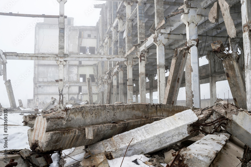 Destroyed large concrete building in a foggy haze with the remains of snow. Background. Destroyed large concrete building in a foggy haze with the remains of snow. Background.