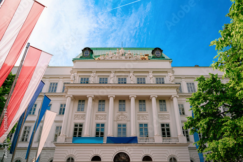 Main building of TU Wien, or University of Technology with flags in Vienna, Austria. Wien, Europe. Panorama, cityscape. Street archtecture and landmark of Educational institute. Austrian town