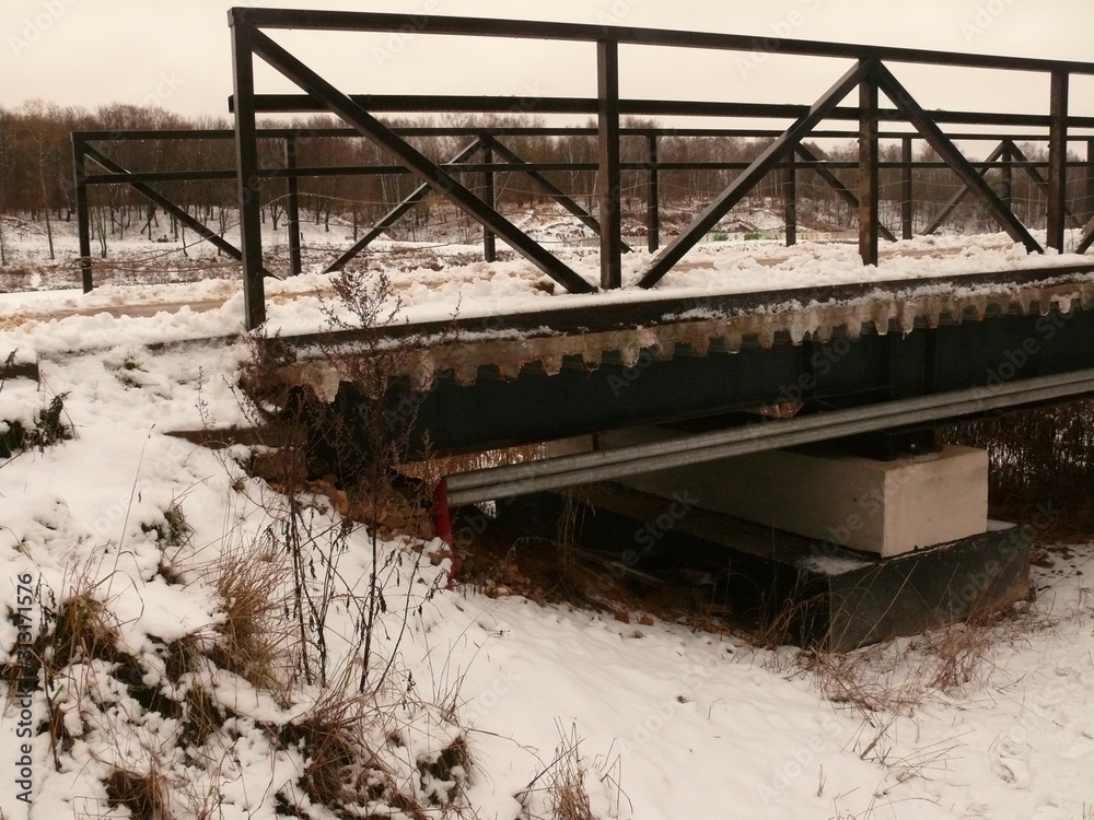 a fragment of the bridge structure over a small river. a fragment of the bridge structure over a small river.