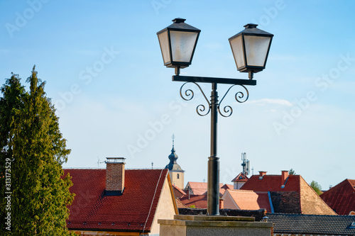 Cityscape with street lantern and house roofs with Our Lady of the Seven Sorrows Church in Old center in Slovenska Bistrica near Maribor in Slovenia. South Styria in Slovenija. Light in Slovenian town