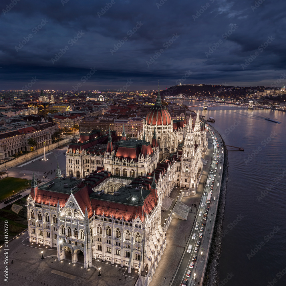 Budapes, Hungary - Aerial drone view of the beautiful illuminated Parliament of Hungary at blue hour with Szechenyi Chain Bridge, St. Stephen's Basilica, Buda Castle and Citadel at background
