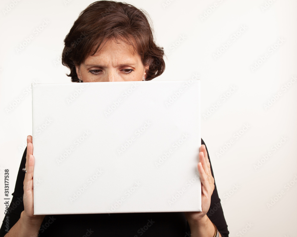 Woman holding up a blank white sign with room for your copy Woman holding up a blank white sign with room for your copy