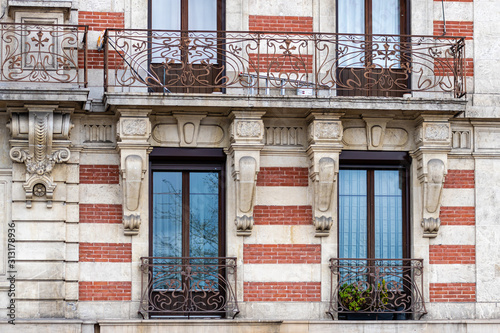 Facade of a historic brick building with metal balconies. Geneva, Switzerland