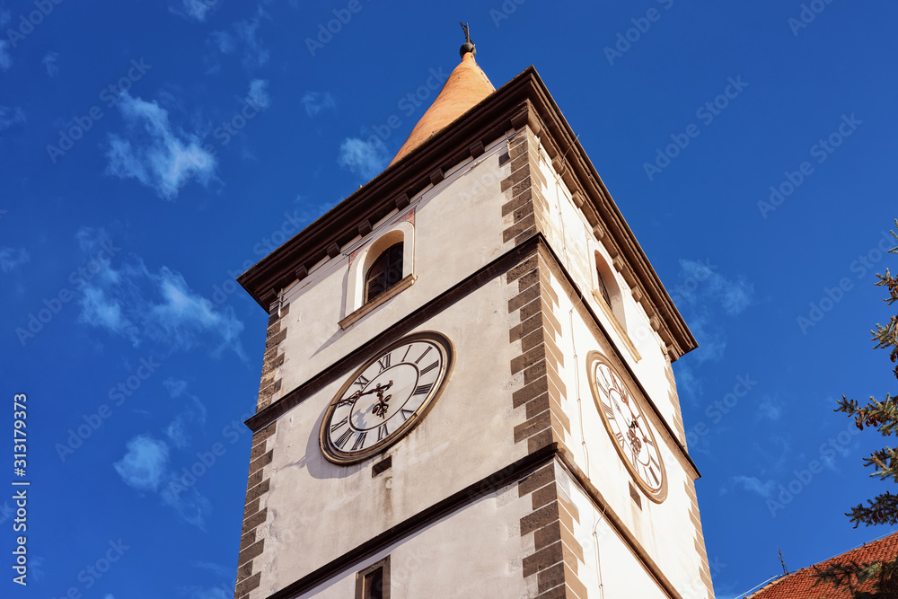Clock tower of St Nicholas Church in Old city of Varazdin in Croatia. Cityscape with belfry in famous Croatian town in Europe in summer. Travel and tourism. Blue sky