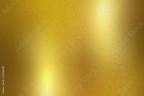 Gold foil metallic wall with glowing shiny light, abstract texture background