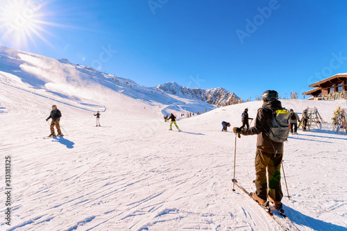 Men Skiers skiing in Hintertux Glacier of Tyrol in Mayrhofen in Austria, winter Alps. People Ski at Hintertuxer Gletscher in Alpine mountains with white snow. Austrian snowy slopes. Sun shining.
