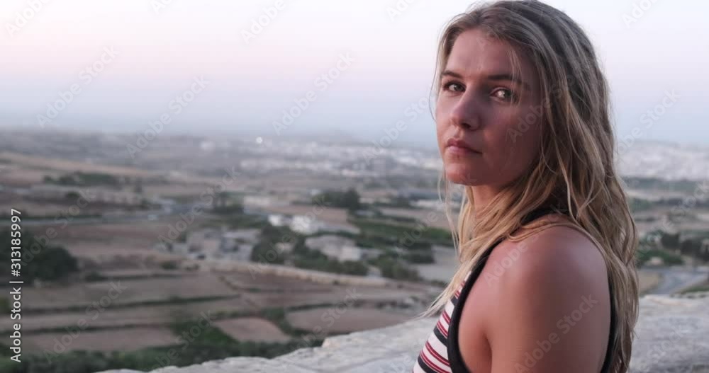 beautiful incredible blonde woman on holiday looking towards camera filmed in prores raw slow motion with gorgeous city backdrop at sunset with soft lighting and hair moving in the wind part three beautiful incredible blonde woman on holiday looking towards camera filmed in prores raw slow motion with gorgeous city backdrop at sunset with soft lighting and hair moving in the wind part three