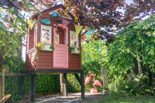 Children's play house on leafy area of garden