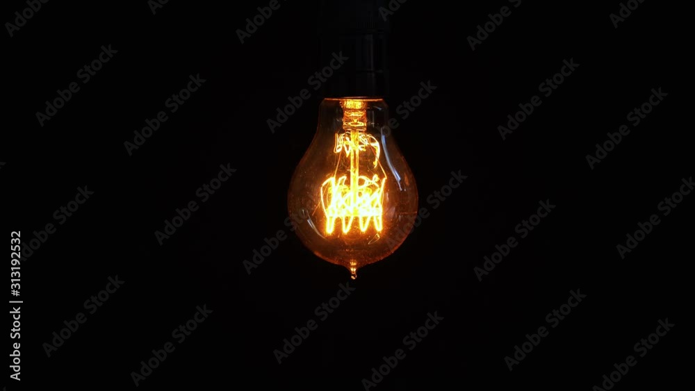 Light bulb turns on and off over dark background Light bulb turns on and off over dark background
