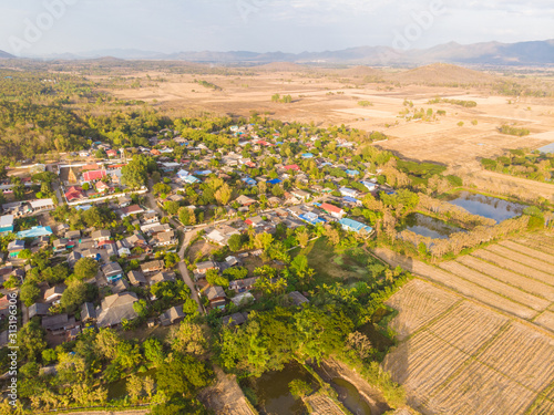 Rice plantation field show soil development preparing to glow paddy rice with village photo