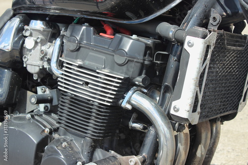 Obraz na płótnie Four cylinder four carburettor four stroke motor bike inline engine with cooling fins and cooling radiator close up w salonie