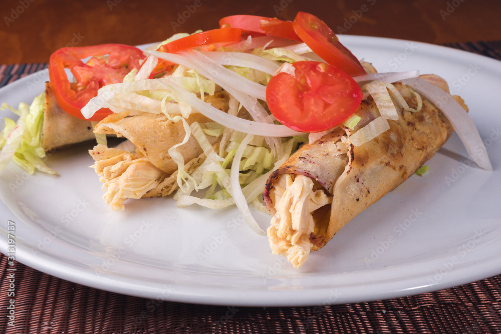 tacos dorados de tortilla dorada con pollo lechuga queso y vegetales