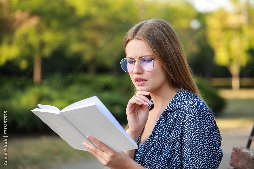 Beautiful young woman reading book in park Beautiful young woman reading book in park
