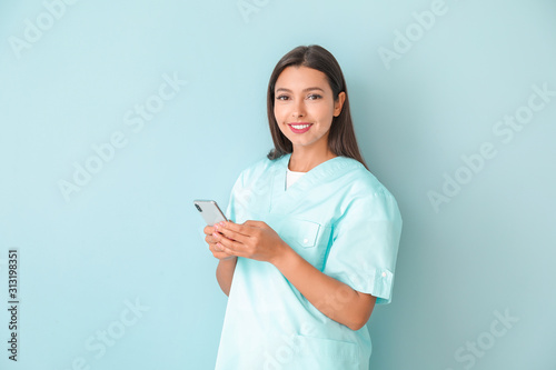 Young nurse with mobile pho...