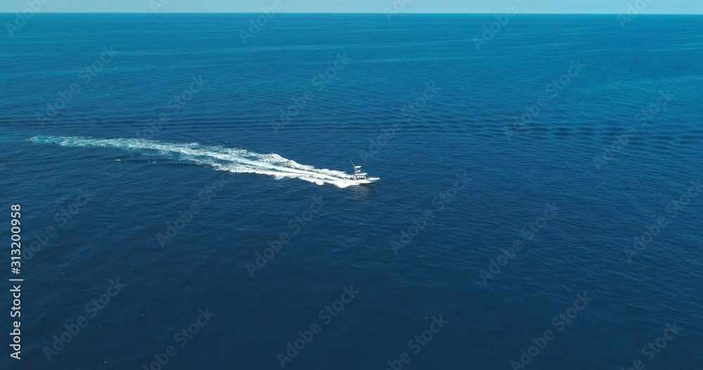 Aerial over blue ocean, pan right as dive boat passes, Roatan Aerial over blue ocean, pan right as dive boat passes, Roatan