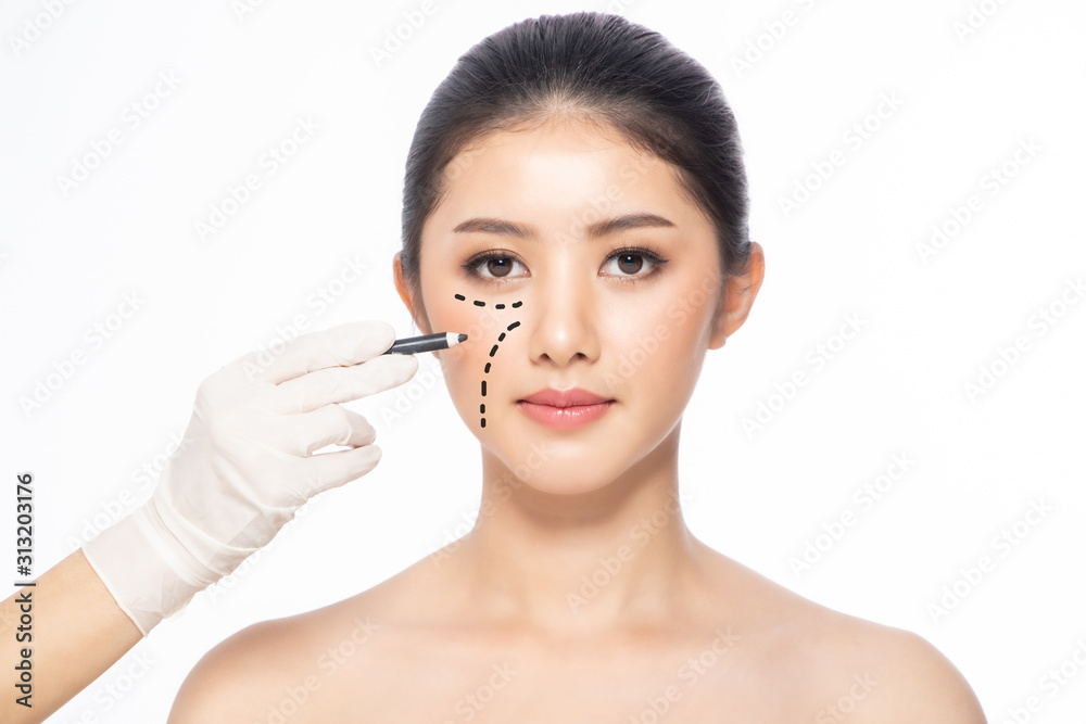 Lines on face, close up, plastic surgery concept, doctor's hand in glove making marks on patient's face..Asian beauty Woman in beauty salon. plastic surgery clinic. Lines on face, close up, plastic surgery concept, doctor's hand in glove making marks on patient's face..Asian beauty Woman in beauty salon. plastic surgery clinic.