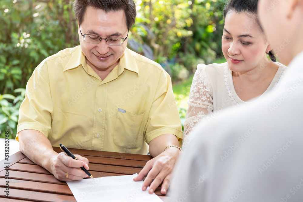 Senior Asian couple signing documents and meeting financial advisor and insurance coverage. Senior Asian couple signing documents and meeting financial advisor and insurance coverage.