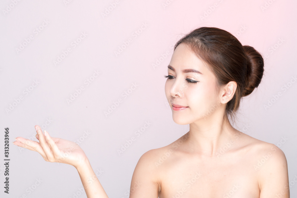 Beautiful young woman with clean fresh skin, Hair sleek, Proposing a product. Gestures for advertisement on pink background, Front view, with copy space. Beautiful young woman with clean fresh skin, Hair sleek, Proposing a product. Gestures for advertisement on pink background, Front view, with copy space.