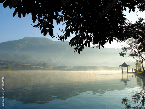 Beautiful scenery during sunrise with the water reflection of the small pavilion at the Lee Wine Ruk Thai lake, Mae Hong Son, north of Thailand.