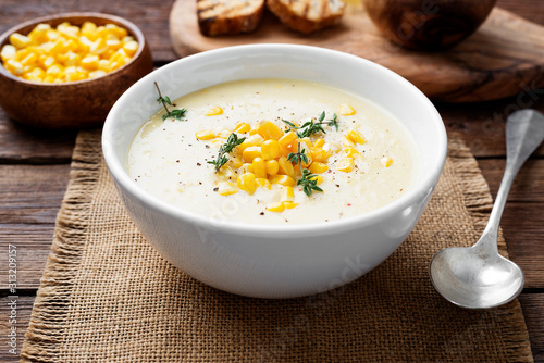 Delicious creamy sweetcorn soup served with toast and corn grains.