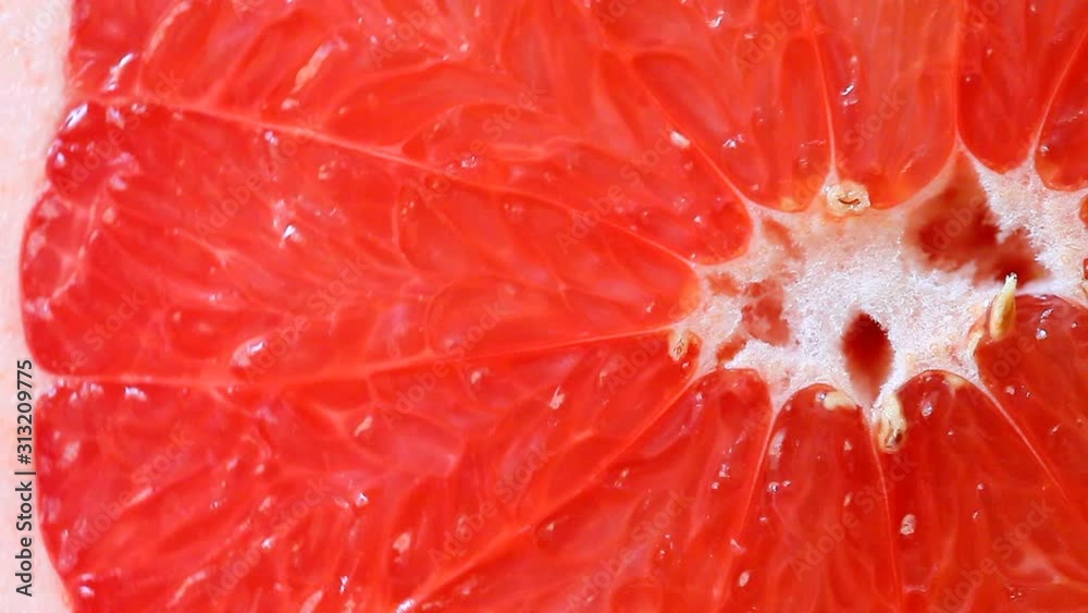 Grapefruit cut red juicy rotates spins around its axis, fresh, citrus fruit. Macro top view. Grapefruit cut red juicy rotates spins around its axis, fresh, citrus fruit. Macro top view.