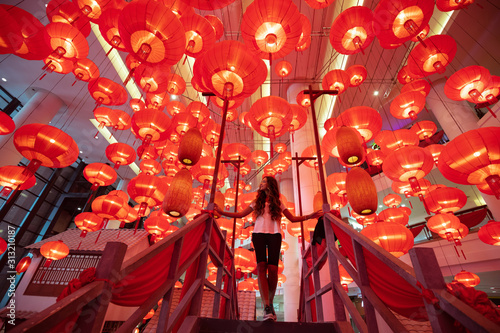 Photography Woman walking and enjoying traditional red lanterns decorated for Chinese new year Chunjie