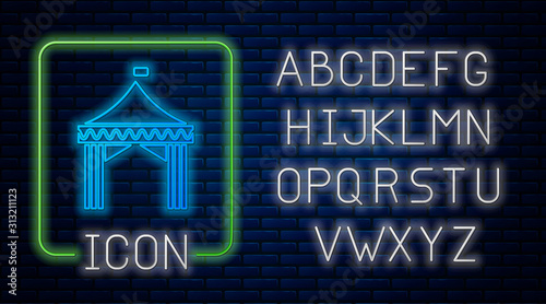 Glowing neon Camping tent icon isolated on brick wall background. Carnival camping tent. Amusement park. Neon light alphabet. Vector Illustration