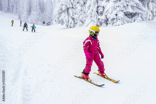 Child skiing in mountains during winter vacation