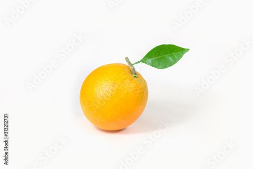 An orange with leaves is isolated on a white background.