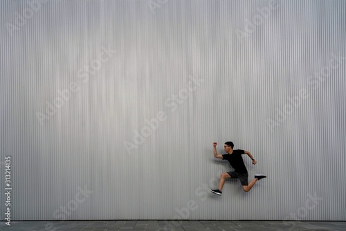 Young Chinese jumping in front of a wall. Healthy and sportive lifestyle 