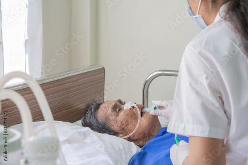 Patients in bed and nurses are preparing to suck up the airways and lungs in the  old aged patients. photo