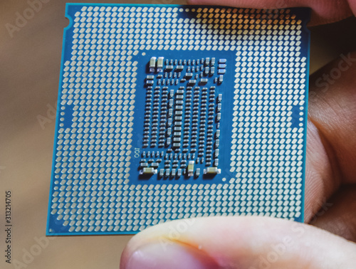 The processor is a desktop computer in hand. Inspect the CPU contacts before installing photo