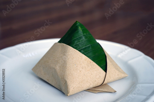 Pyramid of Malaysian Nasi Lemak fragrant rice wrapped in pandan leaf and paper photo