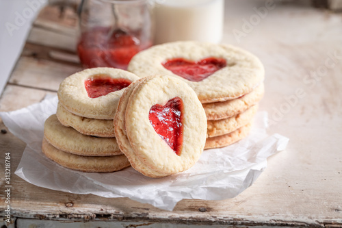 Fotografia Tasty biscuits for valentine with red strawberries jam