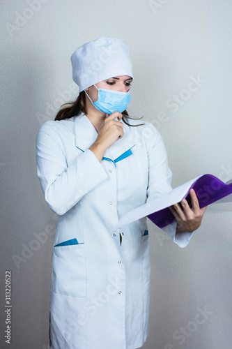 doctor woman in medical mask looking paper on white background  photo