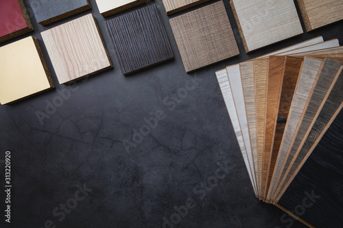 wood texture laminate furniture and flooring material samples on dark stone background with copy space