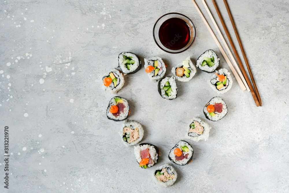 Set sushi roll in the shape of a heart on a stone table
