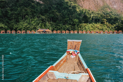 Longtail boat on Cheow Lan lake with raft houses in Khao Sok National Park