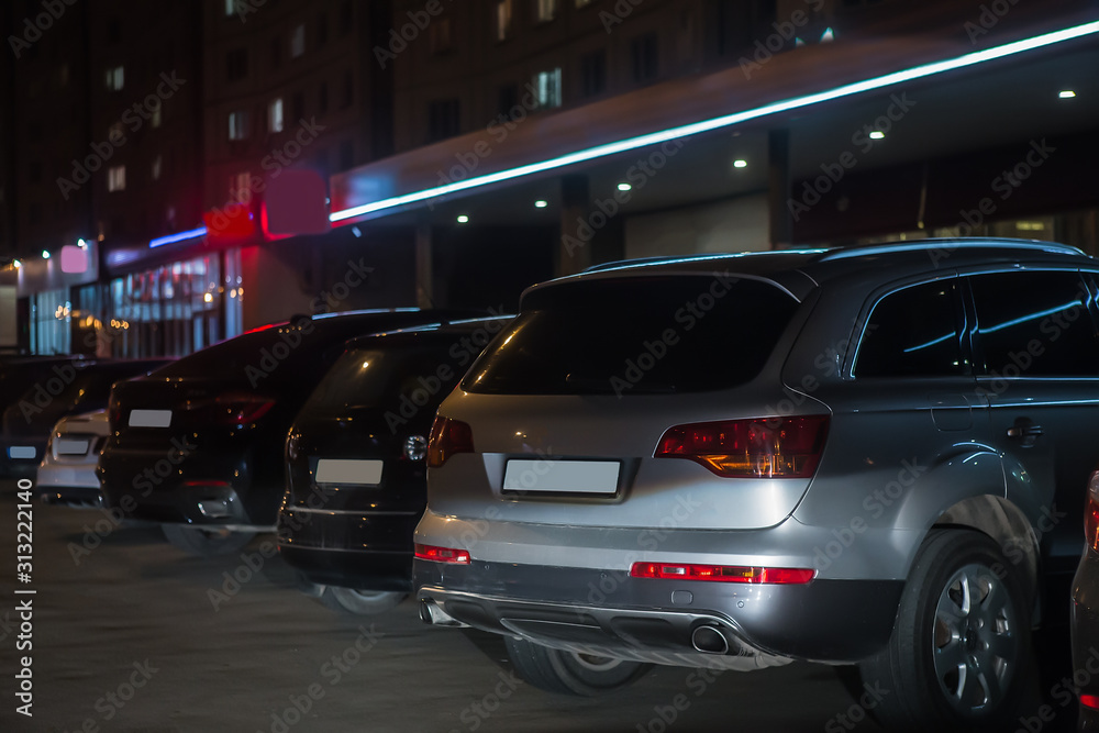 cars at night in the parking lot at the store cars at night in the parking lot at the store