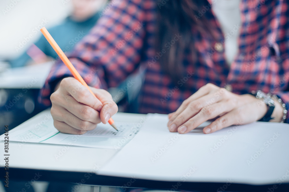 high school,university student study.hands holding pencil writing paper answer sheet.sitting lecture chair taking final exam attending in examination classroom.concept scholarship for education abroad high school,university student study.hands holding pencil writing paper answer sheet.sitting lecture chair taking final exam attending in examination classroom.concept scholarship for education abroad