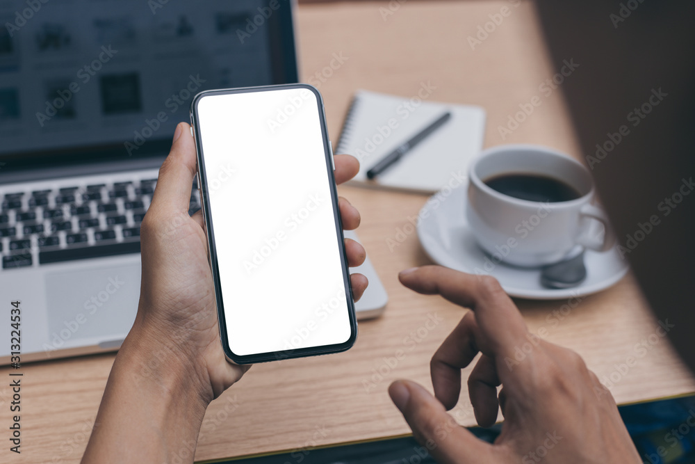 Mockup image blank white screen cell phone.man hand holding texting using mobile on desk at office.background empty space for advertise text.people contact marketing business,technology 