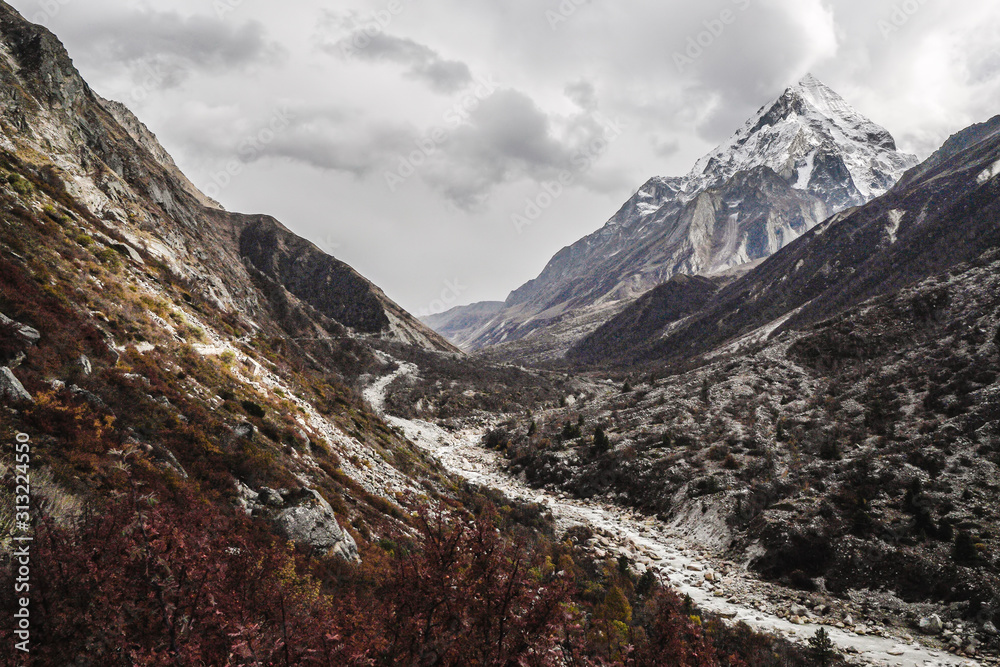 Gangotri National Sanctuary, Uttarakhand, India, snow covered Mount Bhrigupanth with Bhagirathi river running in the foreground on an overcasted day Gangotri National Sanctuary, Uttarakhand, India, snow covered Mount Bhrigupanth with Bhagirathi river running in the foreground on an overcasted day