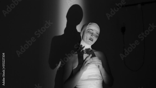 Mad girl with a bandaged head. A girl showing aggression and panic in behavior. Black and white video.
