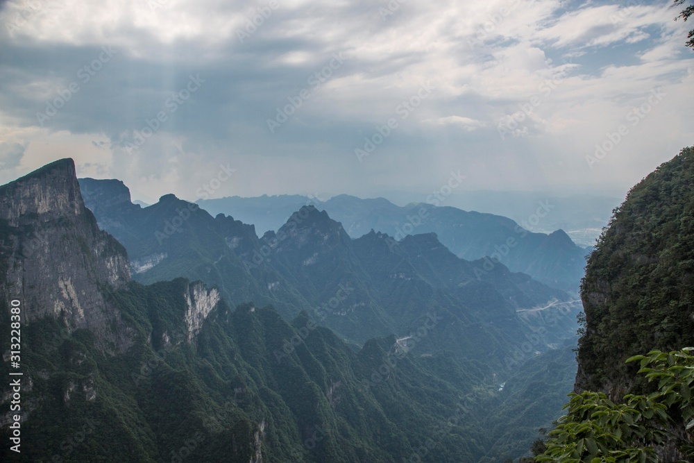 Fototapeta premium Tianmen Mountain Known as The Heaven`s Gate surrounded by the green forest and mist at Zhangjiagie, Hunan Province, China, Asia.